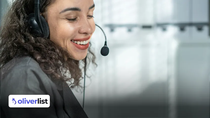 Operatrice sorridente con cuffie e microfono durante una sessione di phoning con un prospect