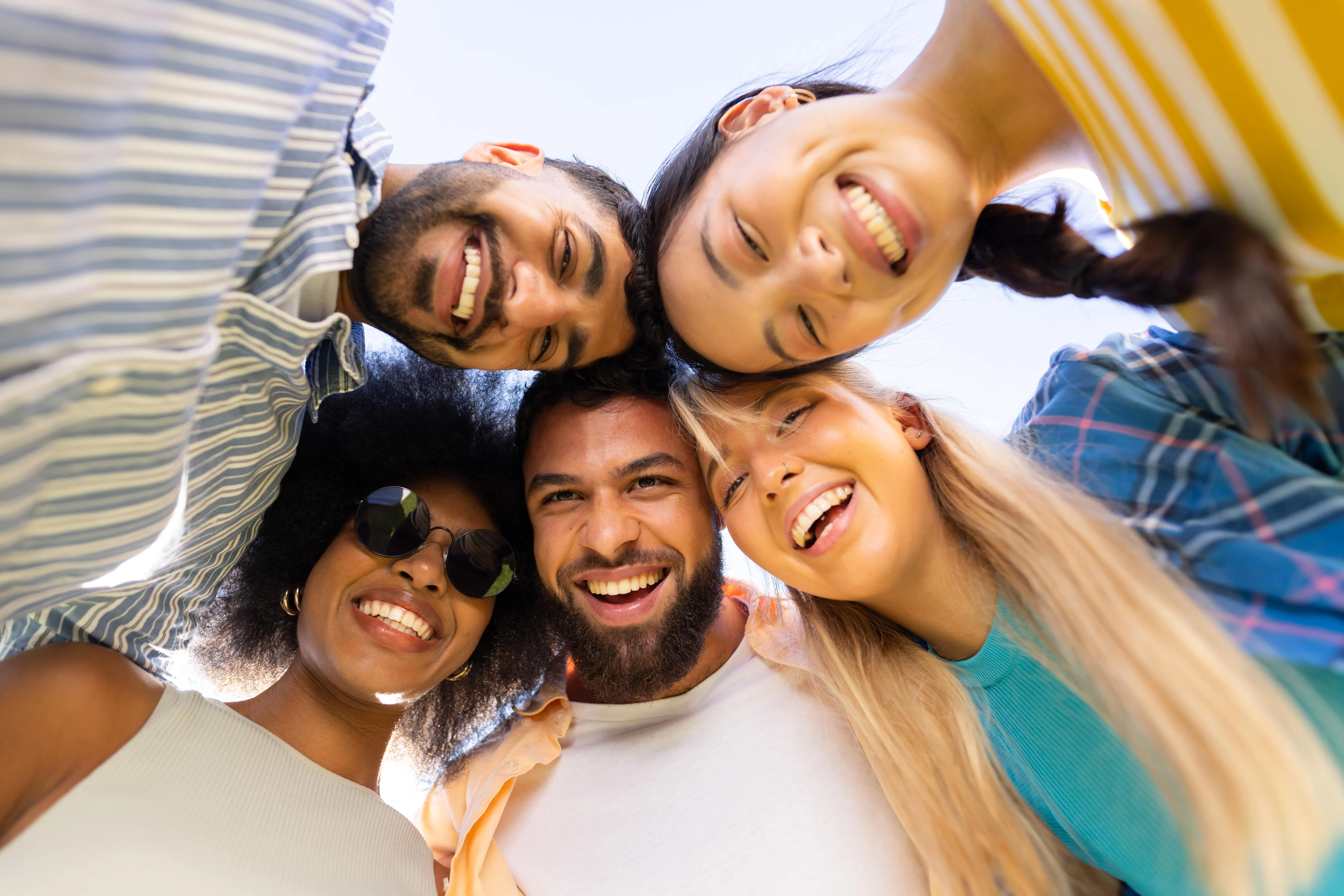 Young group of friends smiling and looking down