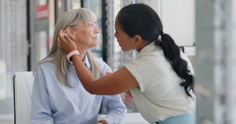 Caregiver comforting and supporting older patient in medical setting