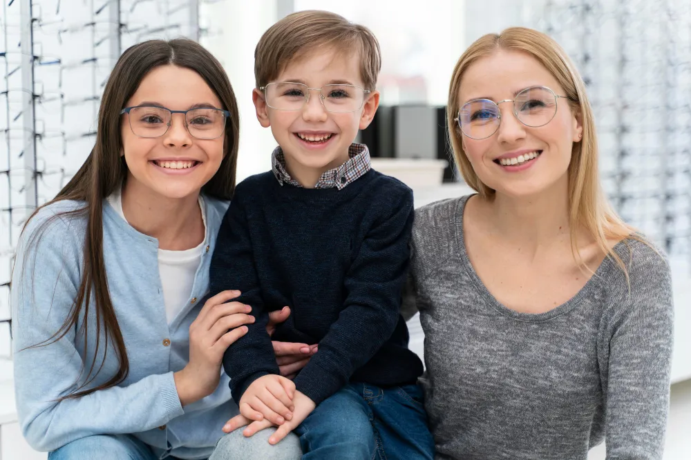 Smiling child with two adults wearing glasses in an eyewear store