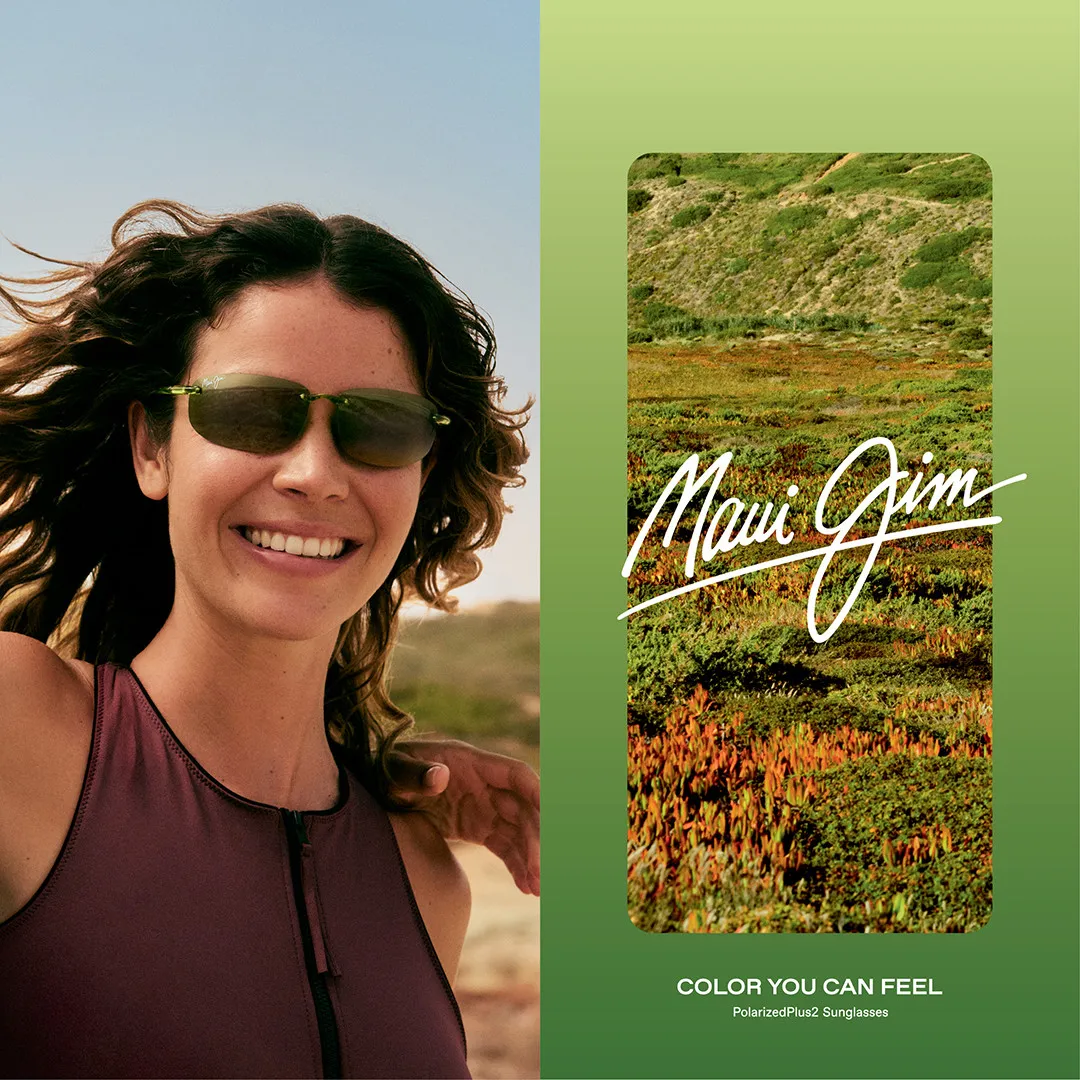 Smiling woman in sunglasses with windblown hair, Maui Jim landscape behind