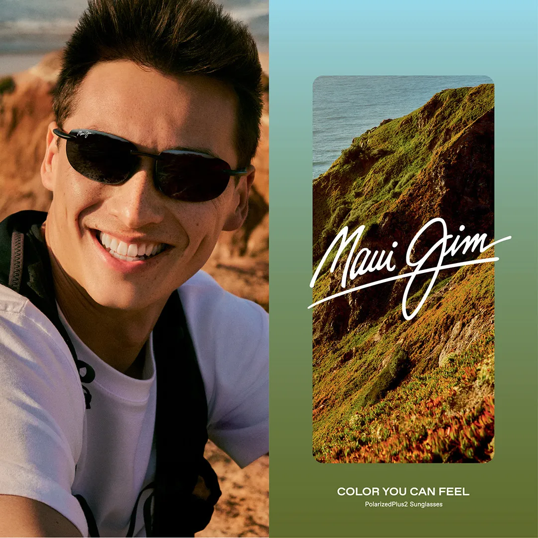 Smiling person wearing sunglasses with coastal landscape and Maui Jim logo