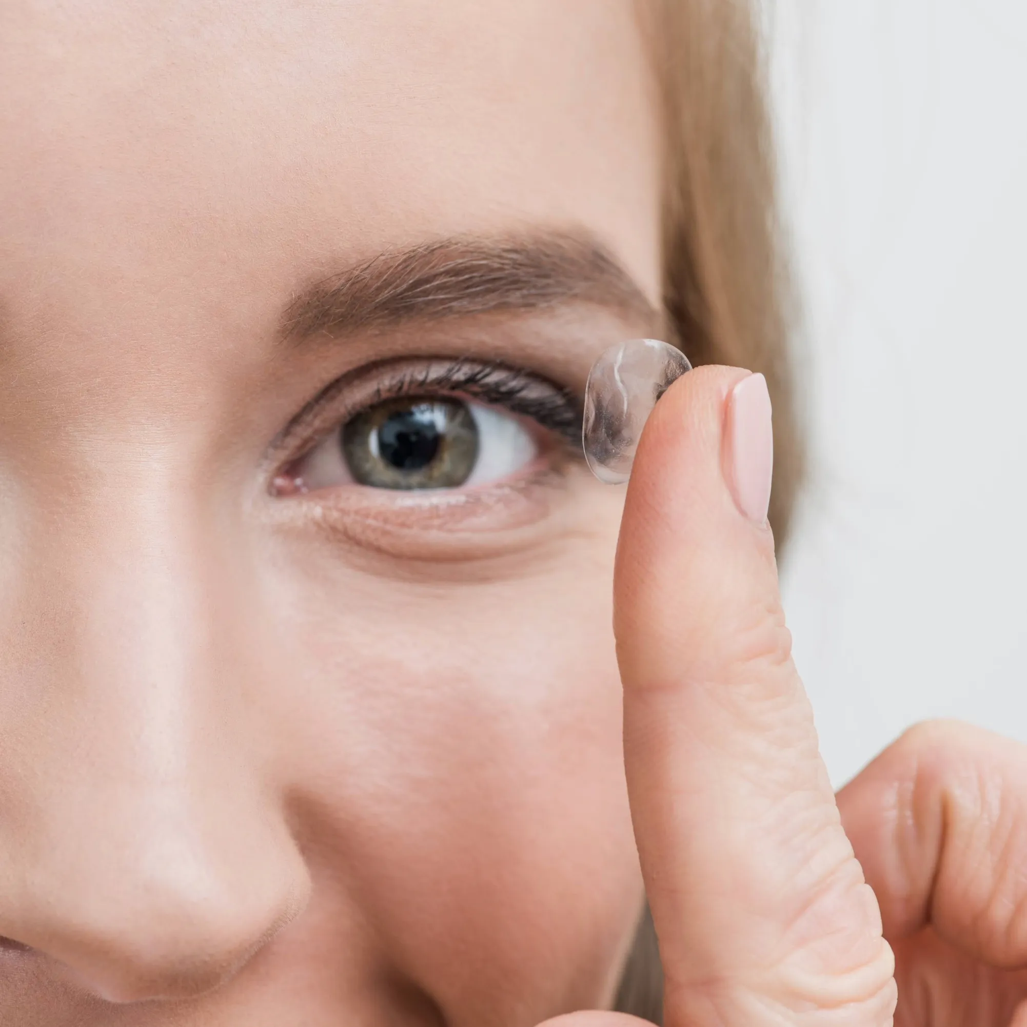 Close-up of a contact lens being placed on an eye