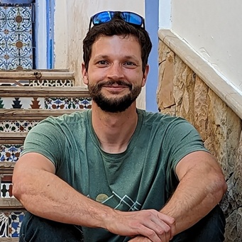 headshot of Adam outdoors