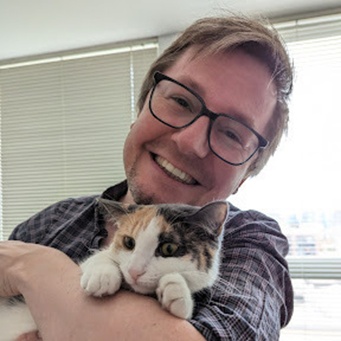 James holding a cat and smiling