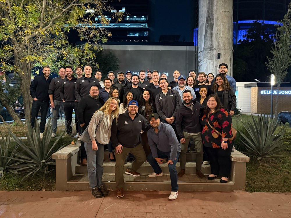 The whole Cargado team in matching fleeces on outdoor steps at night