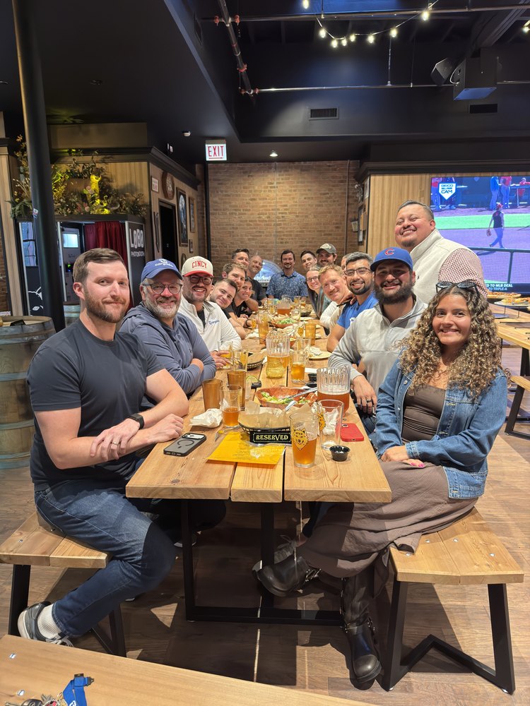 The team smiling around a long dinner table