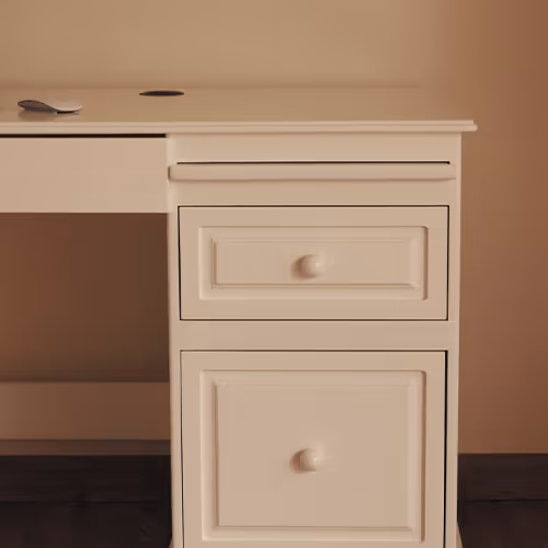 Escritorio blanco con dos cajones en un ambiente con pared beige y piso oscuro.