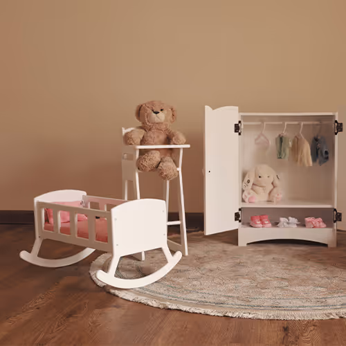 Habitación infantil con cuna mecedora blanca, silla alta con oso de peluche y armario pequeño abierto con ropa de bebé y conejito de peluche.