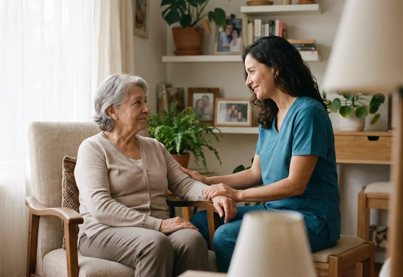 Una mujer mayor conversa con una profesional de salud en el living de su casa