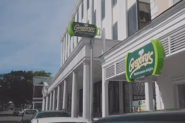 a green and white street sign sitting on the side of a building