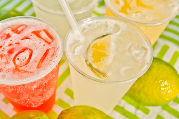 a close up of a bowl of fruit next to a cup of coffee