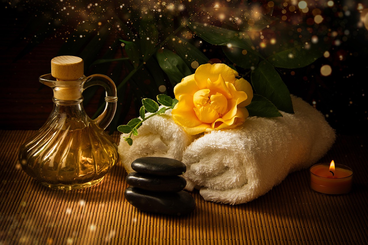 Massage oil, folded towels and a single flower arranged on a table before a couples tantra session in Las Vegas