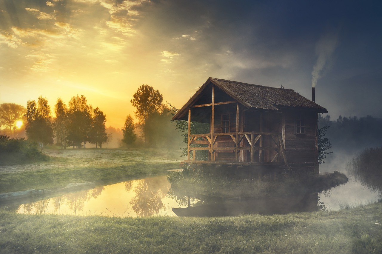A quiet cabin beside still water at sunrise, the kind of setting a multi-day couples retreat uses