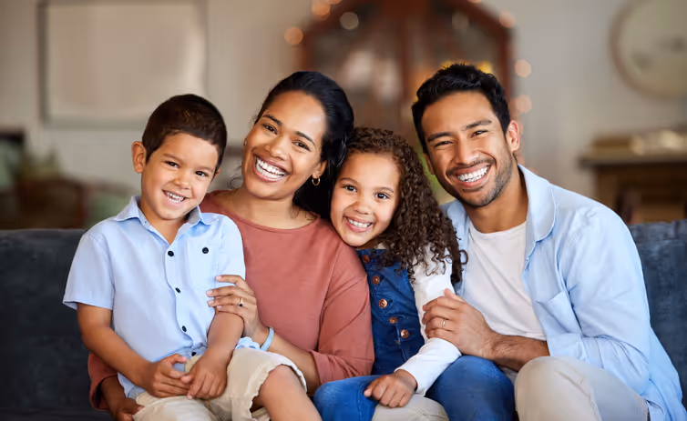Smiling family of four receiving bilingual educational psychologist support in English and Spanish.