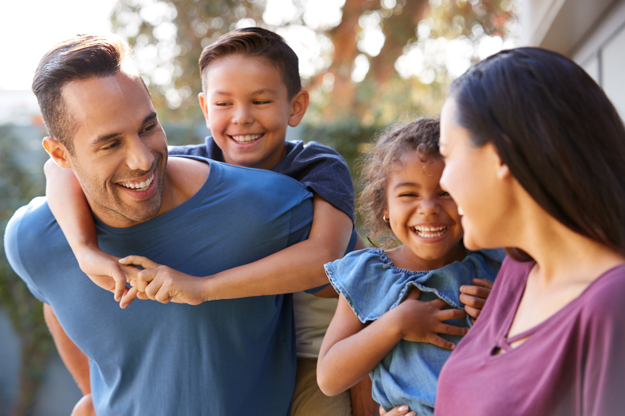 Smiling family of four receiving bilingual educational psychologist support in English and Spanish.