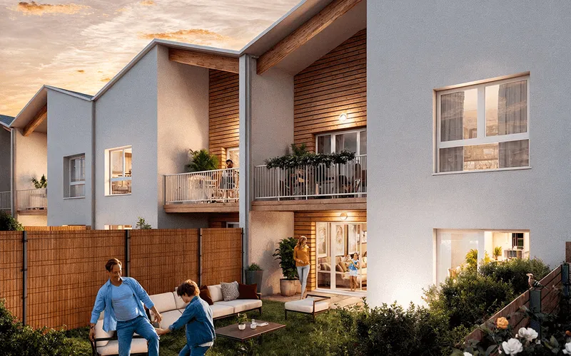 Maison contemporaine avec terrasse et balcon en bois, un homme et un enfant jouant dans le jardin en soirée, et une femme debout près de la porte-fenêtre.