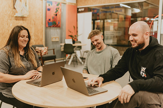a team with laptops sitting around a table