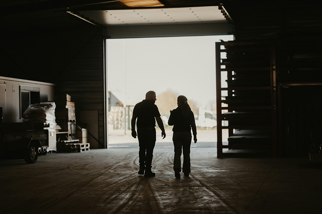 A mentor and a mentee walking through an industrial garage