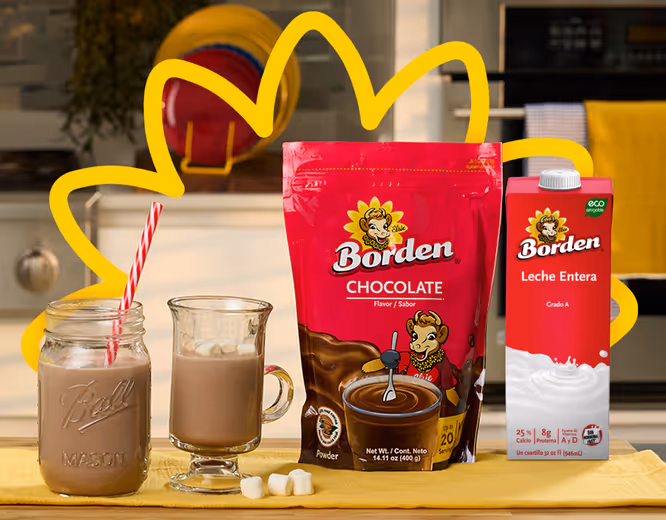 Borden chocolate powder and whole milk carton next to two glasses of prepared chocolate milk with a striped straw and marshmallows on a kitchen counter.