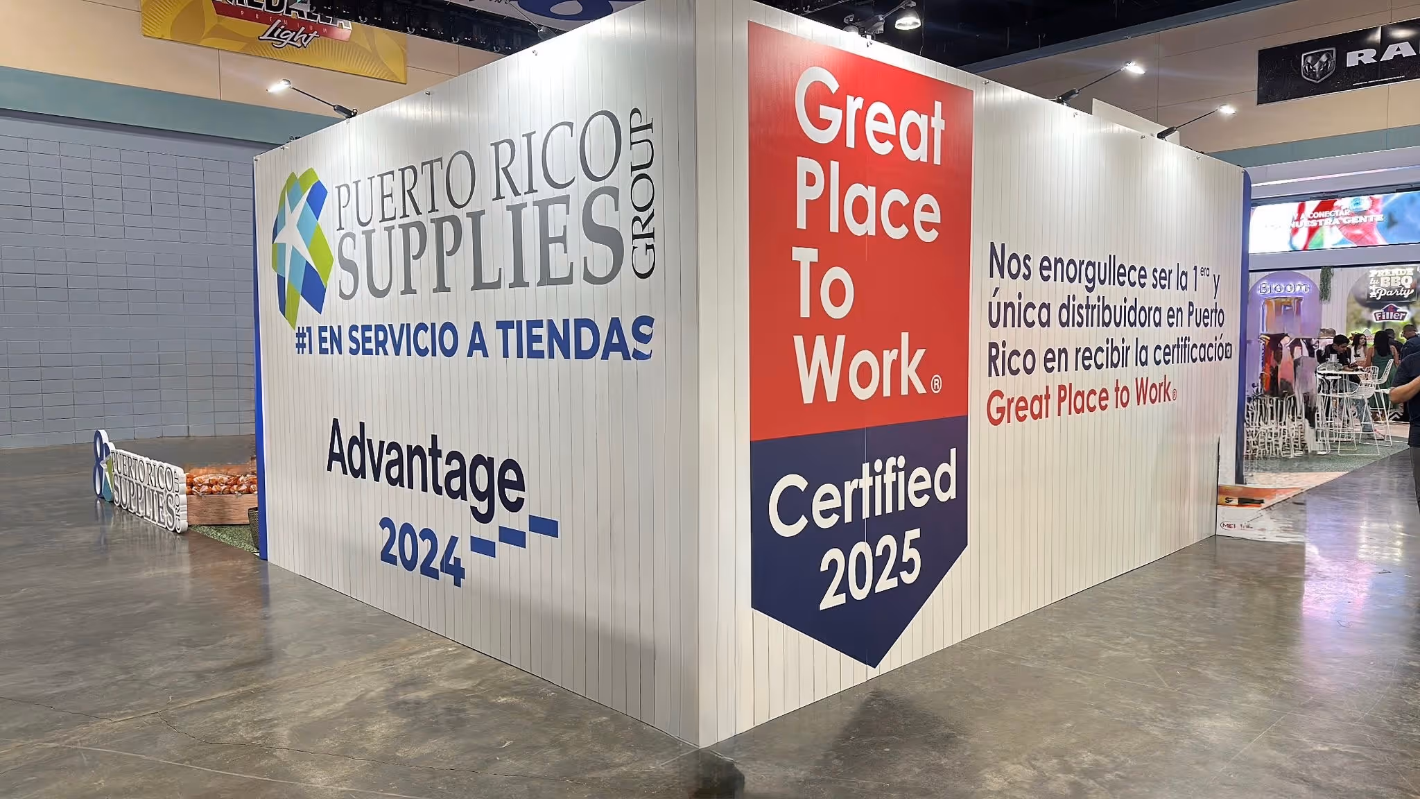 Trade show booth with Puerto Rico Supplies Group branding, highlighting #1 store service and Great Place to Work Certified 2025 recognition.