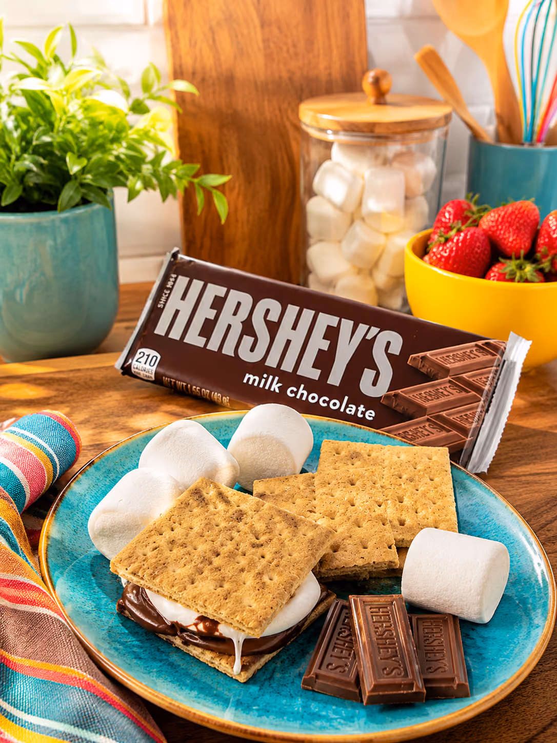 Blue plate with s’mores made from graham crackers, marshmallows, and Hershey's chocolate squares.