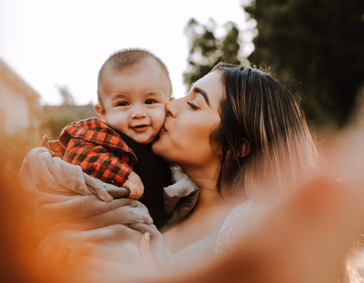 mother kissing a baby