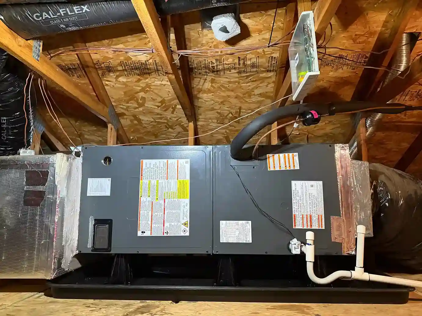 New HVAC air handler in attic with condensate drain pan.