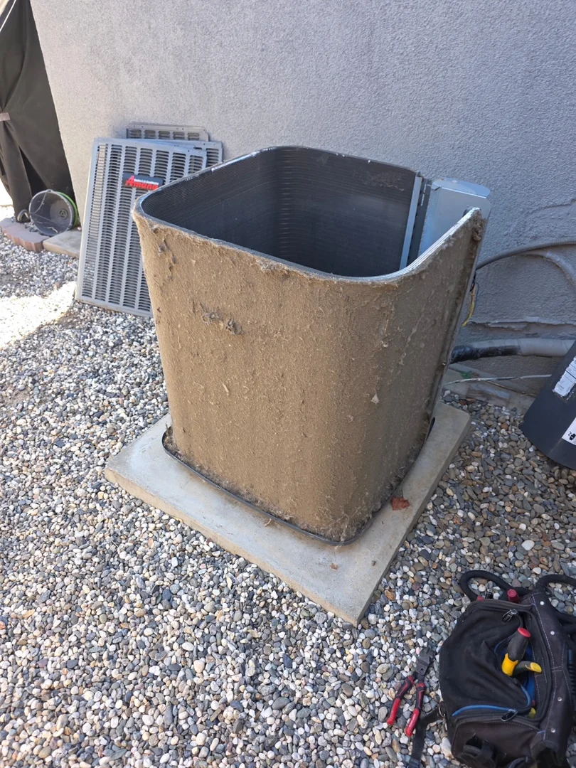 HVAC technician inspecting outdoor condenser coils