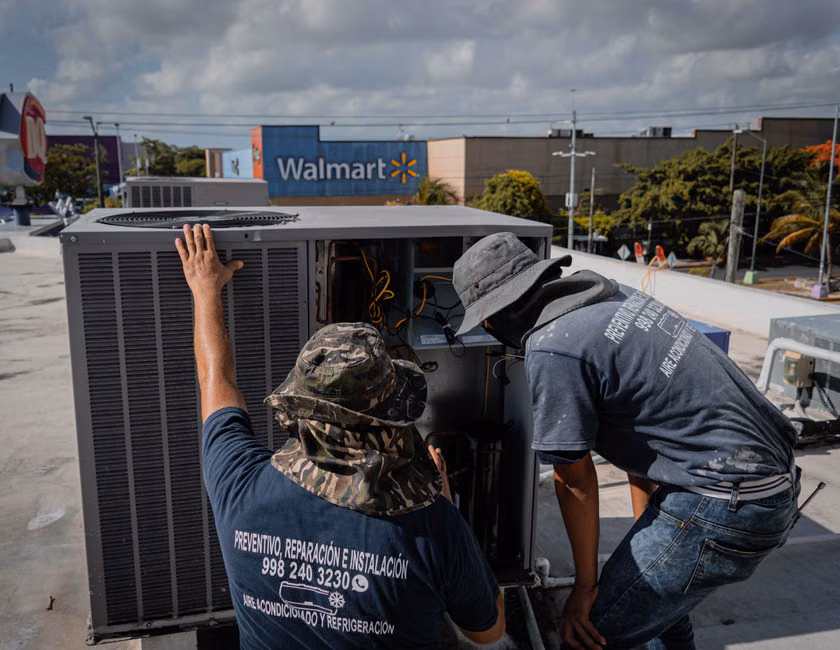 HVAC technician inspecting a large rooftop unit on a commercial building - commercial ac installation in antelope, ca