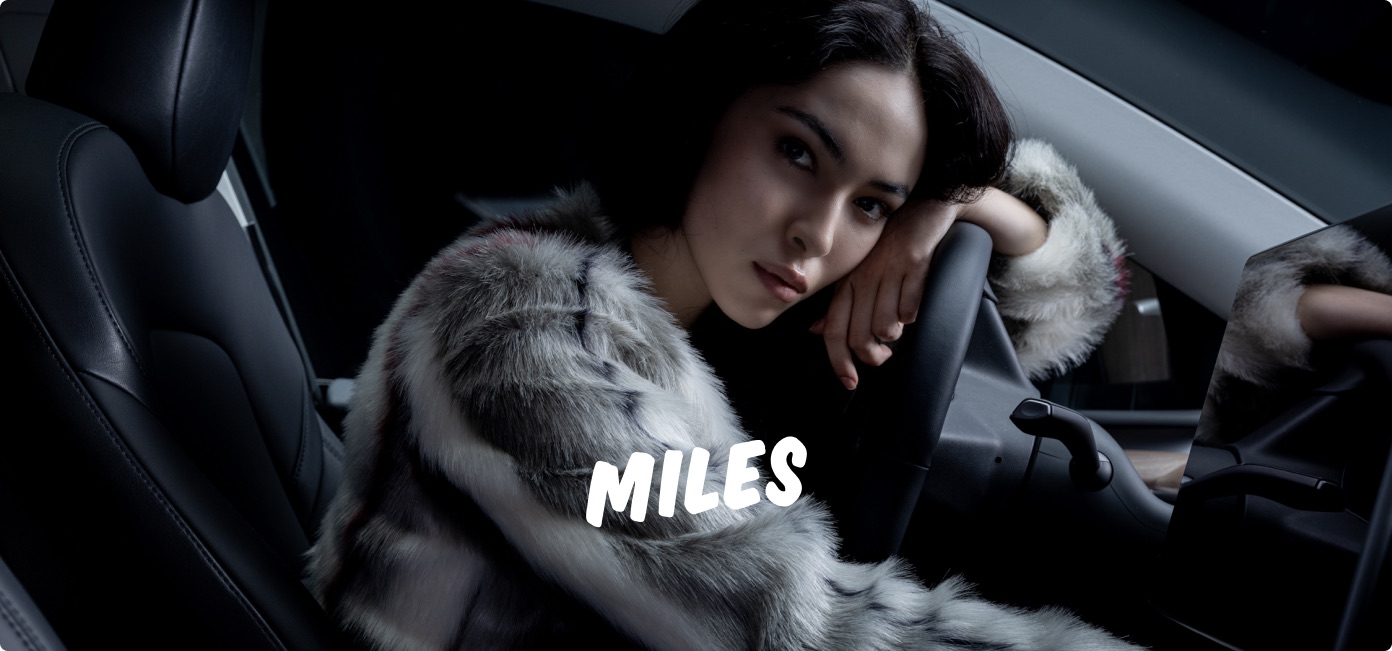 MILES-Kampagnenmotiv mit einer Person im Fahrzeug und weißem MILES-Logo