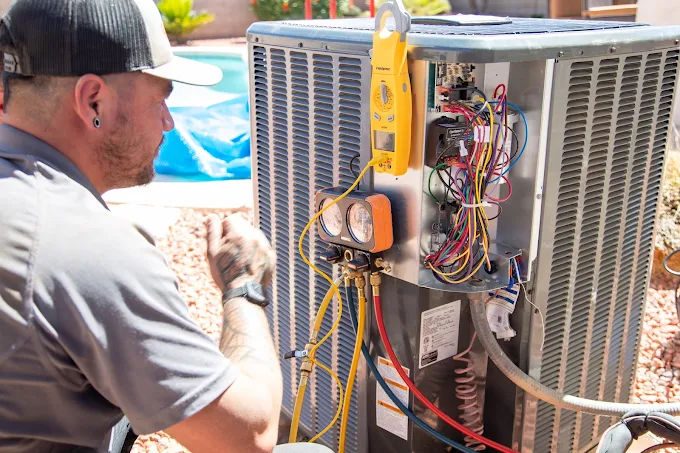Technician inspecting and testing an outdoor air conditioning unit with gauges and meters.
