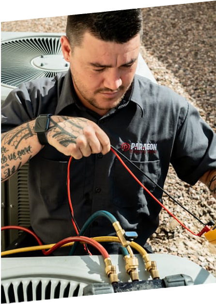 HVAC technician from Paragon Service Pros inspecting air conditioning unit with tools, showcasing expertise in AC repair and maintenance in the East Valley, AZ.