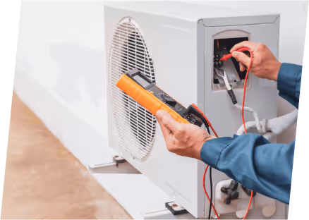 A technician works on an air conditioner, utilizing a tool to adjust the programmable thermostat for optimal performance.