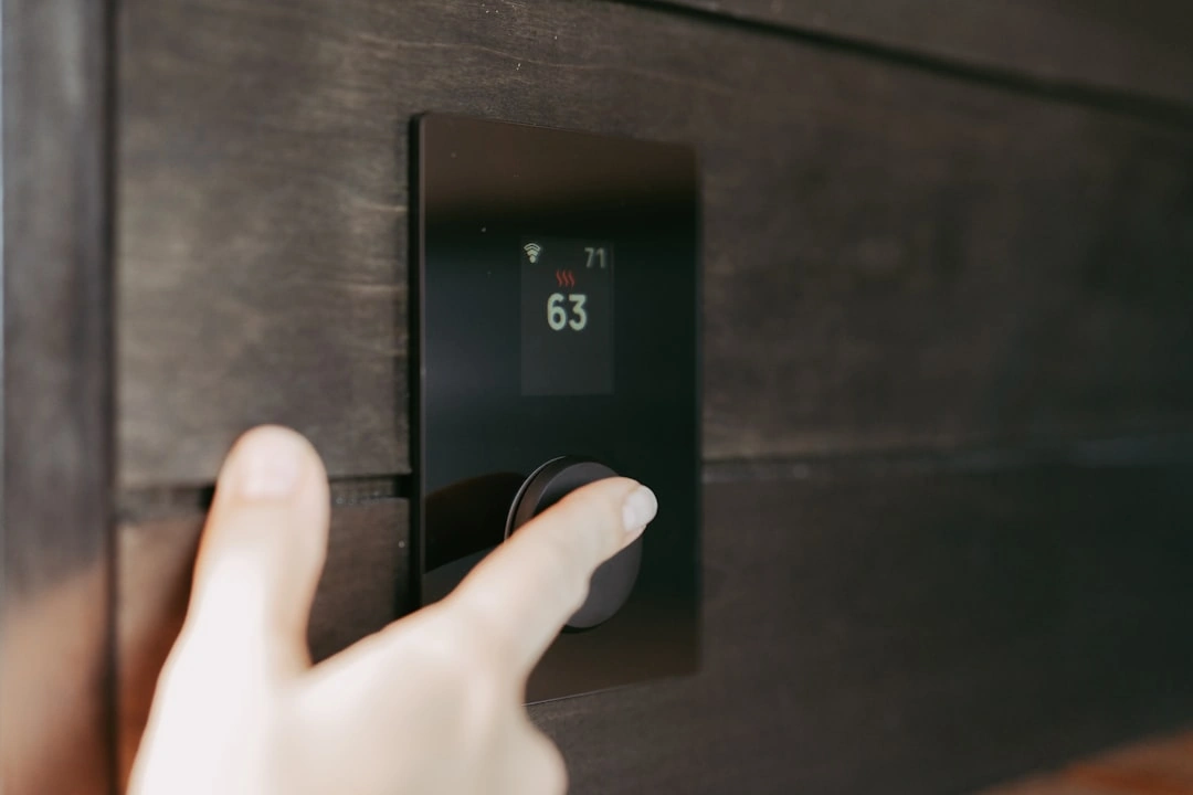 homeowner adjusting a smart thermostat before a storm