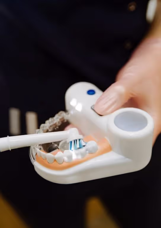 White toothbrush holder with toothpaste being squeezed onto toothbrush