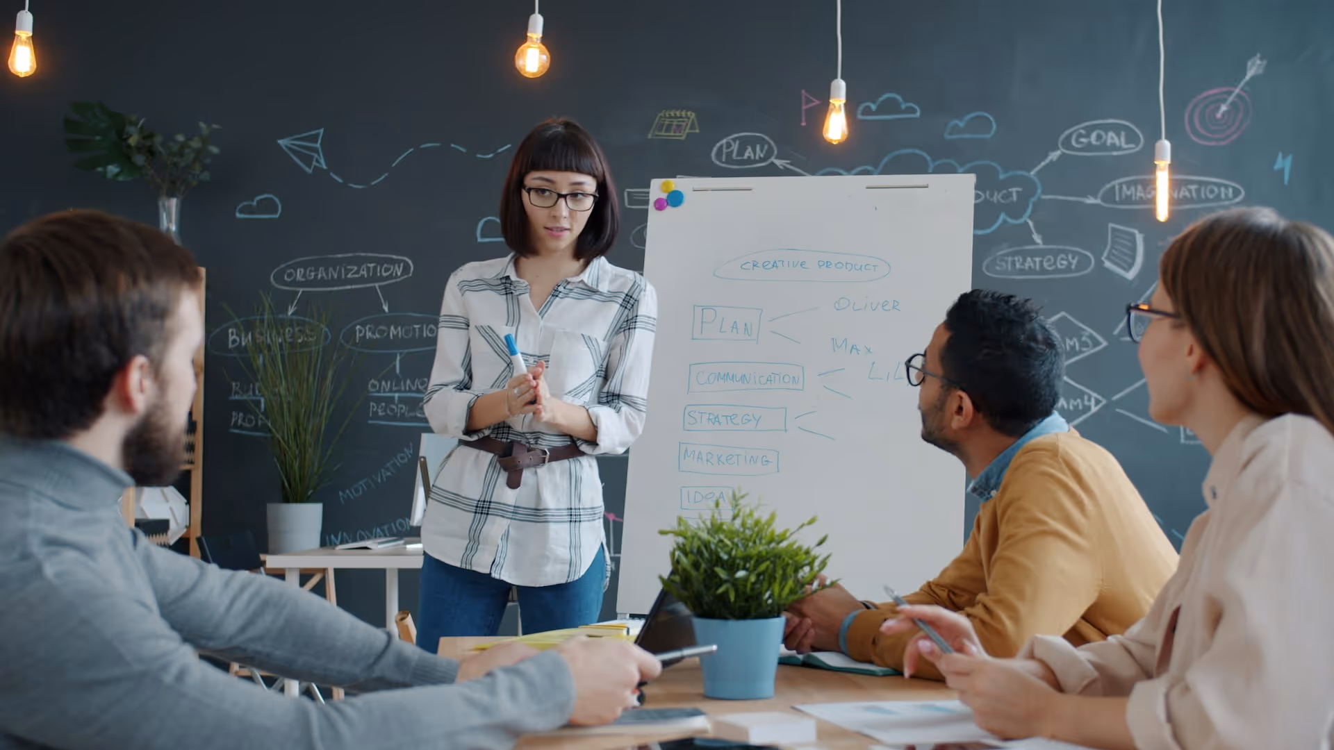 Woman presenting creative business strategy to team in modern office
