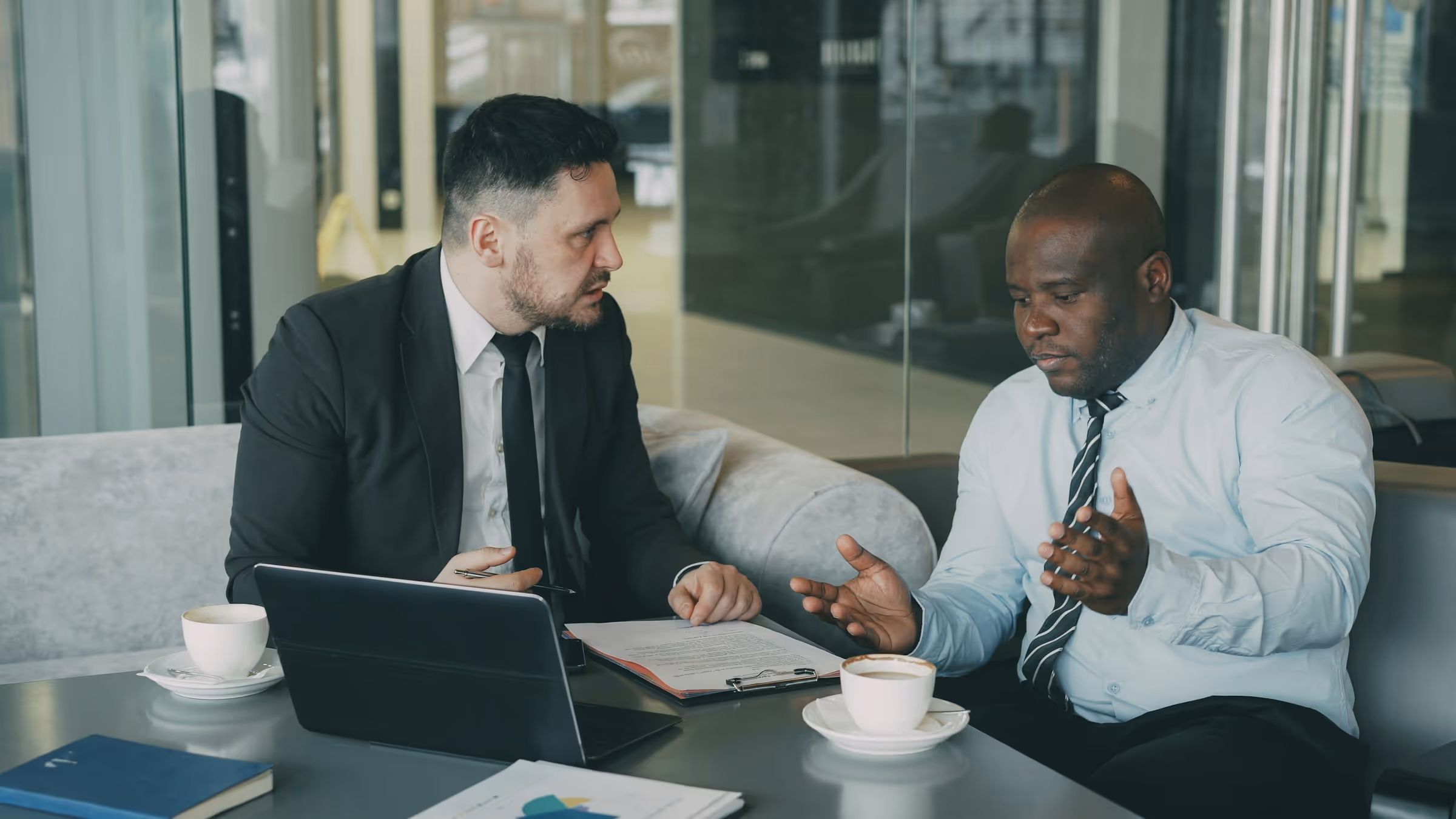 Two businessmen discussing project during meeting in modern office