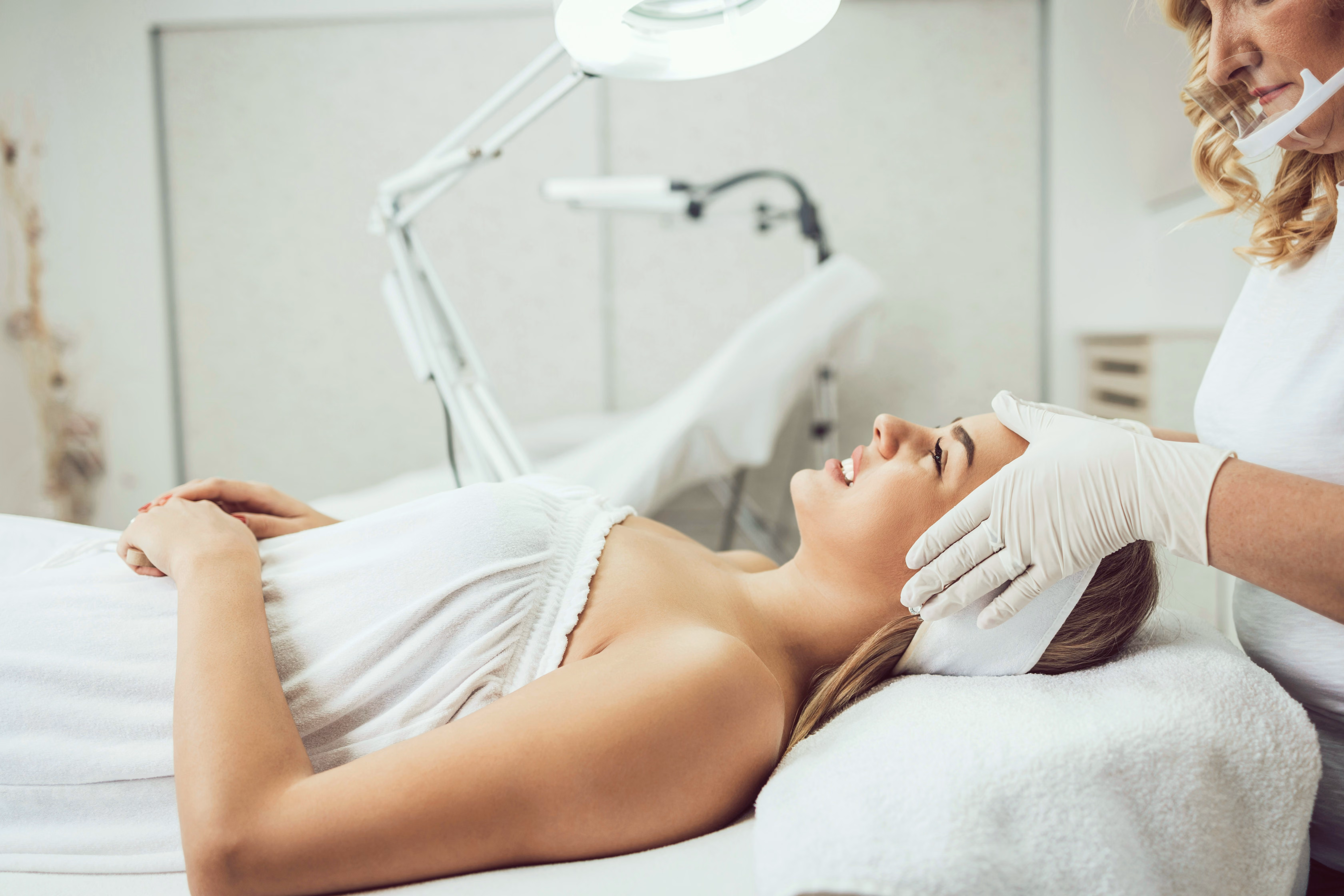 Woman receiving a professional aesthetic facial treatment.