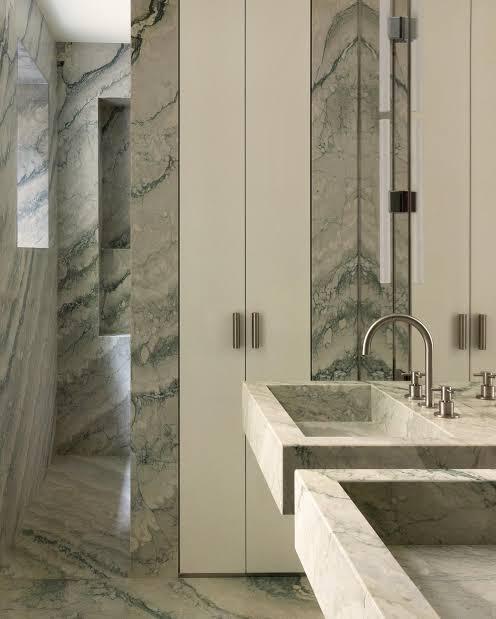 A monochromatic interior featuring sicilly green marble on both walls and floors