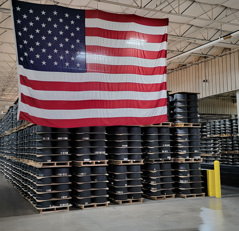 Mechanic wearing orange gloves working on a car brake disc without the wheel attached.