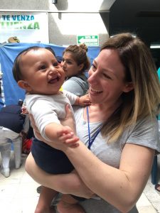 Melissa white holds a smiling baby on a medical mission volunteer trip.
