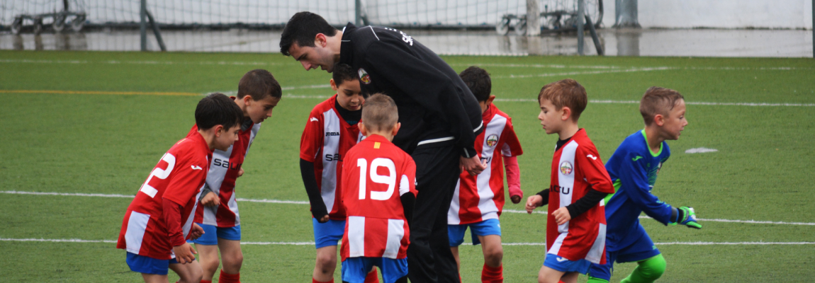 Coach talking to young players in a huddle