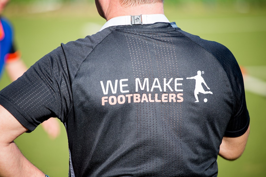 Back of a coach's shirt with the We Make Footballers logo