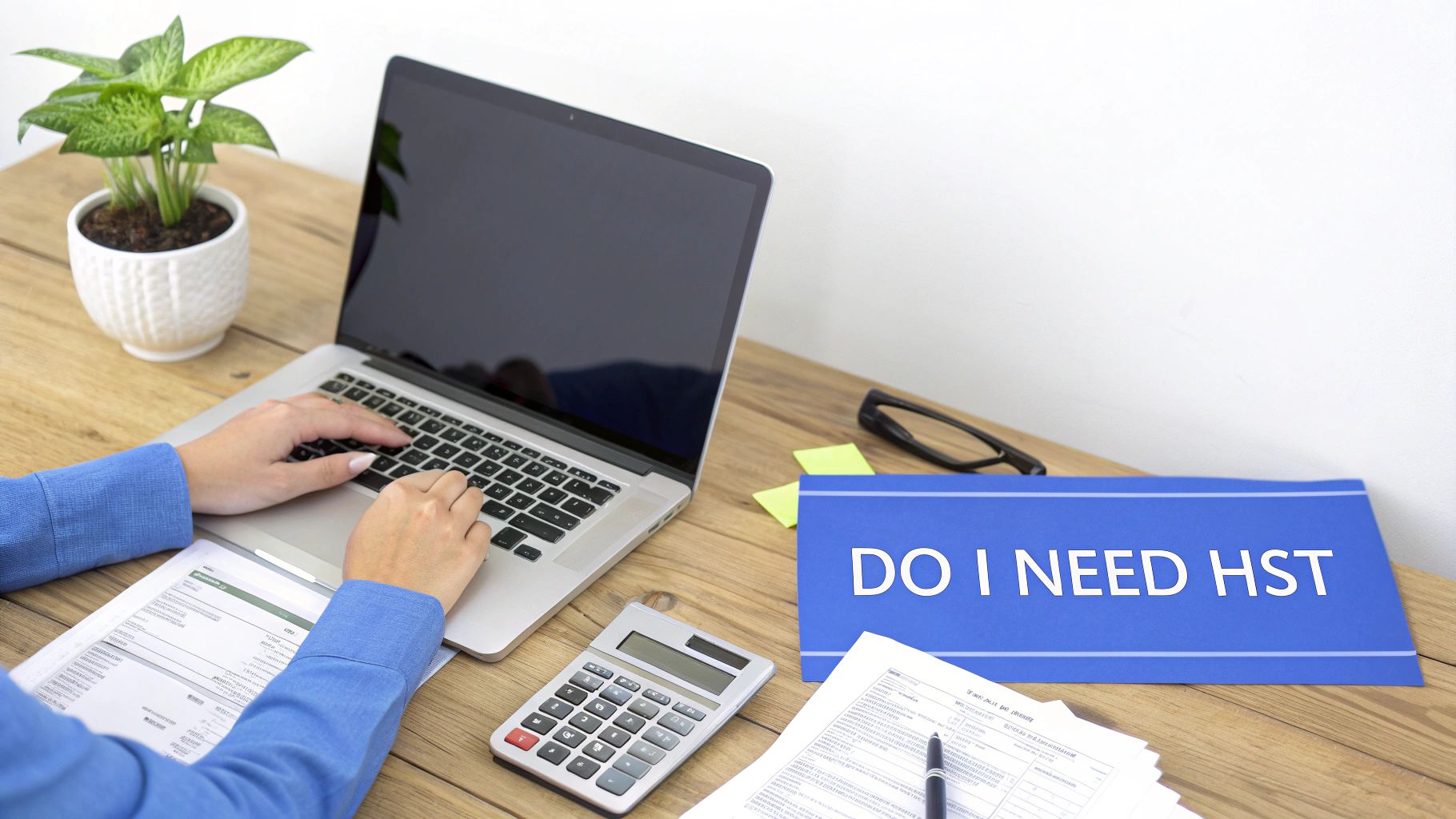 Person using laptop with calculator and documents researching do I need HST registration