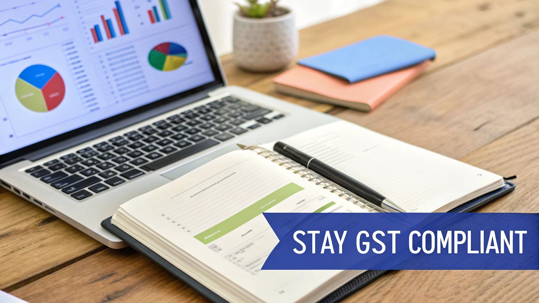 Laptop showing financial data and charts, with an open notebook and pen, highlighting GST compliance.