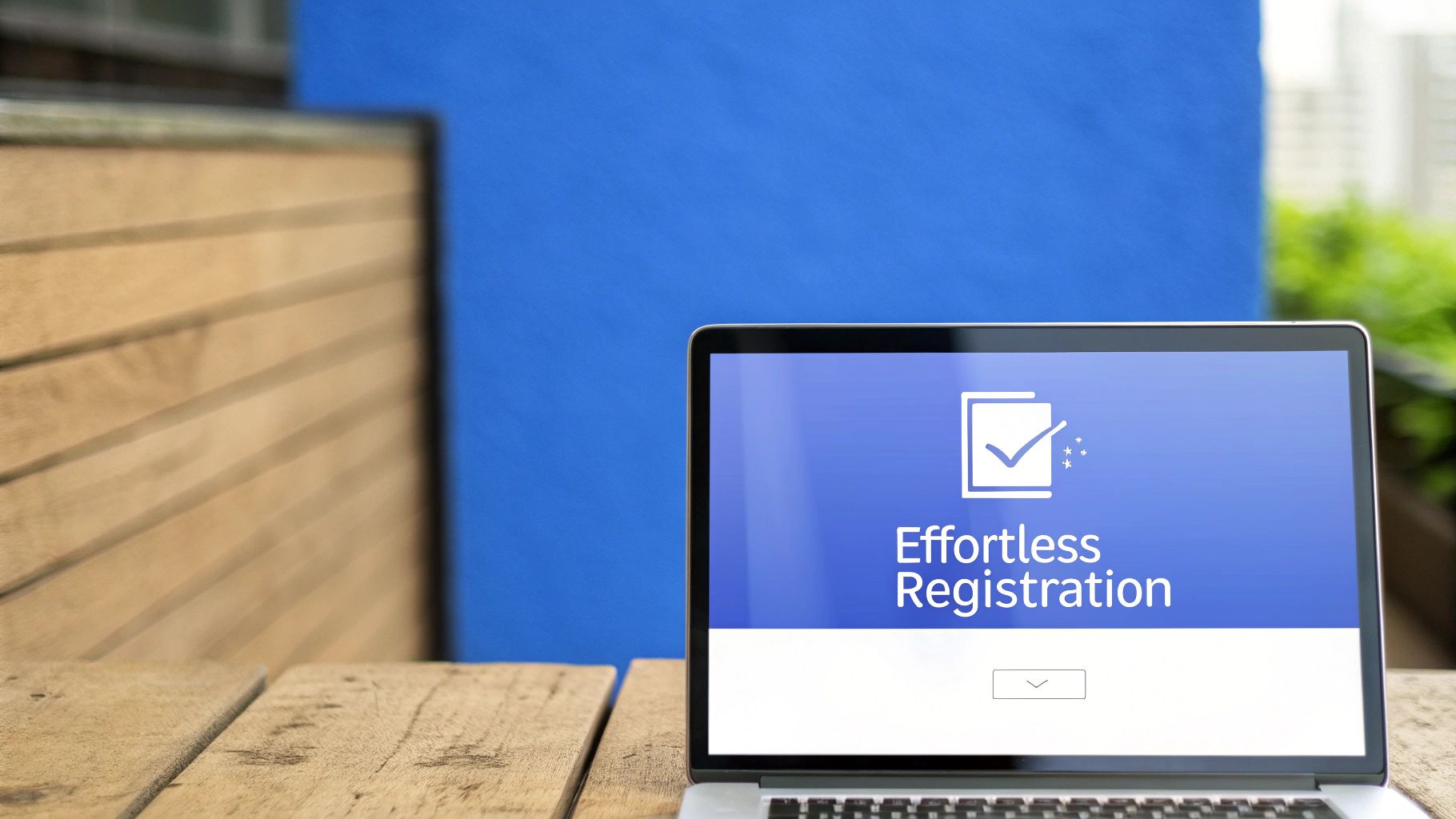 Laptop on a wooden table displays 'Effortless Registration' with a checkmark icon.
