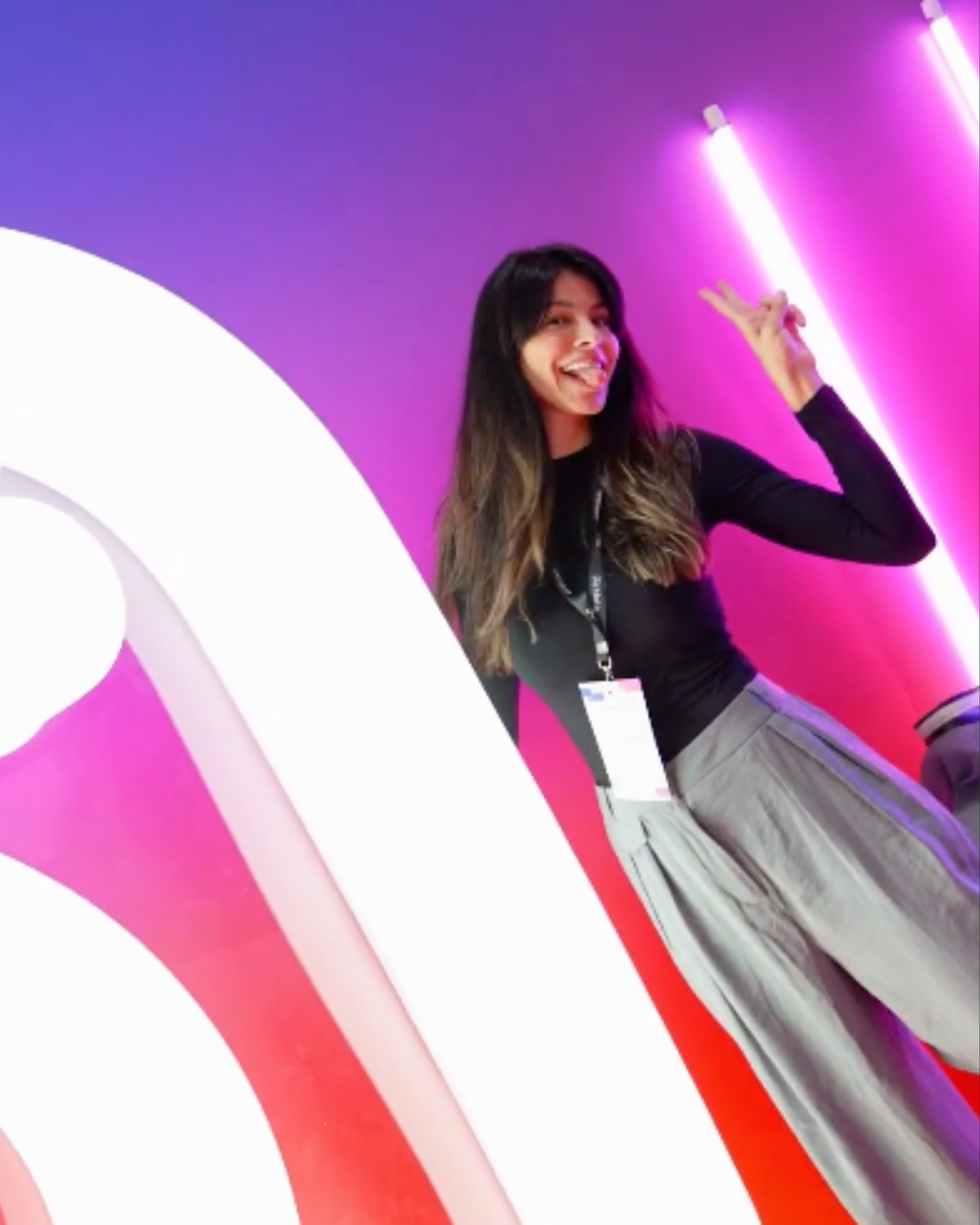 Laptop and smartphone on a mustard-colored fabric surface showing speakers presenting at a 'Conversations' event.