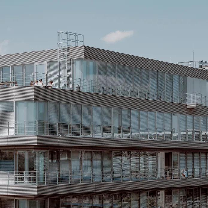 Bürogebäude mit großen Glasflächen und einem blauen Himmel.