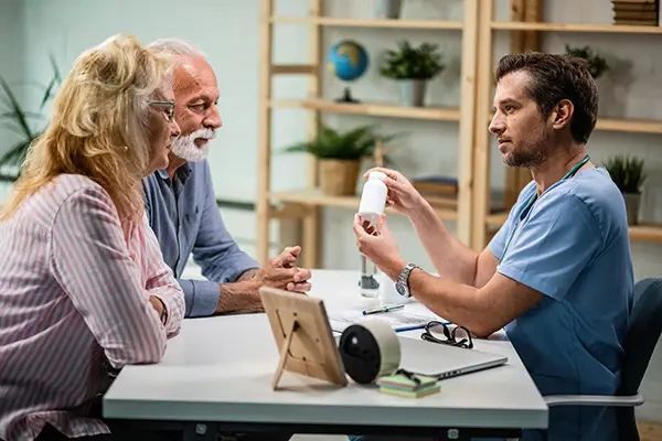 Mature couple having consultations with their doctor who is advising them which vitamins they should take